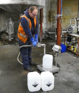 Shows employee filling 10-litre containers with customer formulation